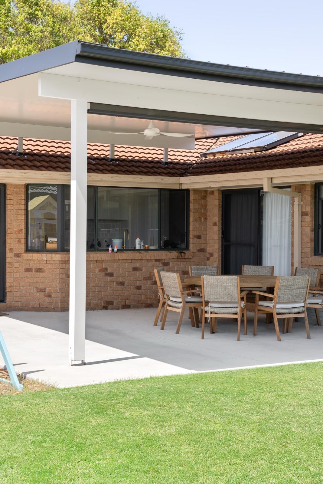Patio on slab with outdoor dining setting and ceiling fan
